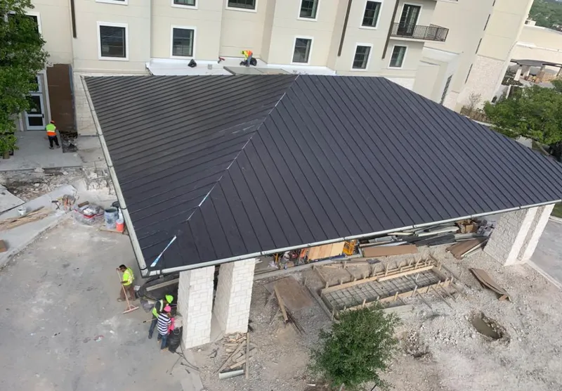 Metal roofing installation team working on a commercial building in Walton